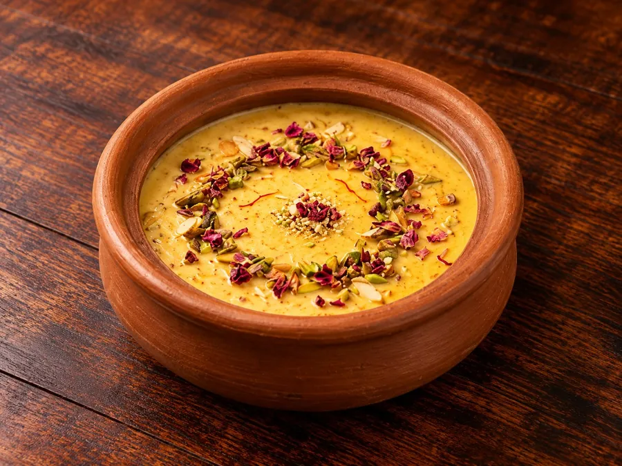 Peshawari Qissa Khawani Kheer in a clay pot, topped with pistachio, almond and rose petals